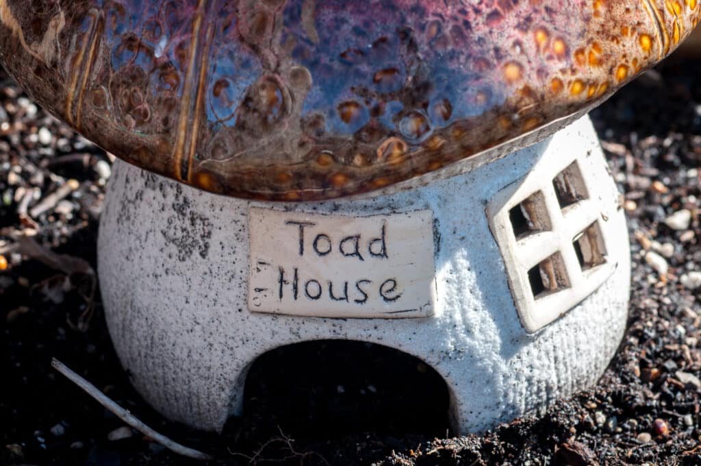 A cute pottery toad house shaped somewhat like a toadstool.