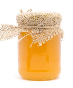 A jar containing a pint of golden-colored honey.