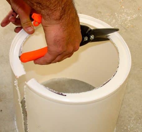 White bucket setting upright and a notch being cut.